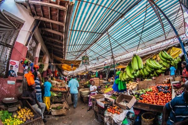 A covered market in Kenya with fruit and vegetable stalls