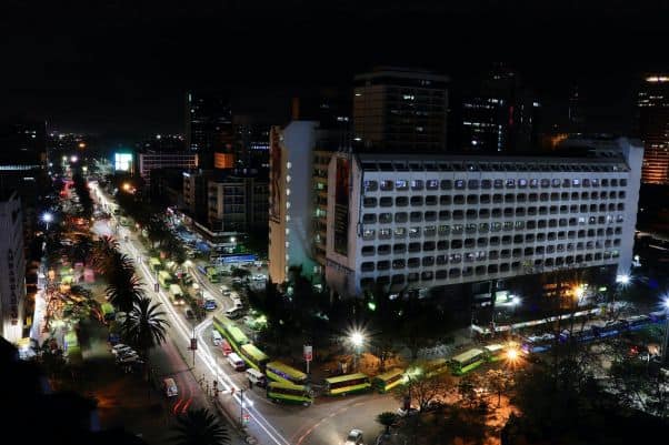 A brightly lit street lined with dark buildings in Nairobi