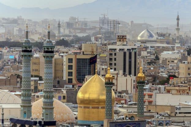A view of mosques and other buildings featuring onion domes and minarets in the city of Qom, Iran.