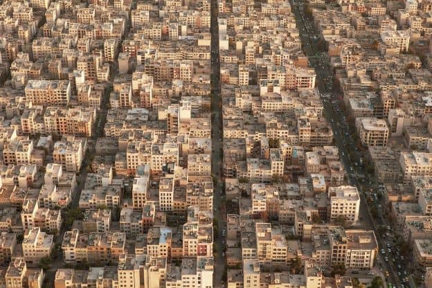 A view from above of a residential area in Tehran, Iran. The houses have largely streamlined rectangular architecture, and are densely packed together.