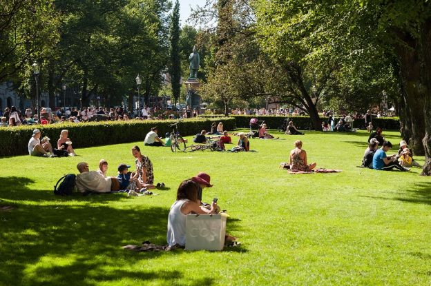 Many people laze on the grass to enjoy spring-like weather at a popular park in Helsinki. 